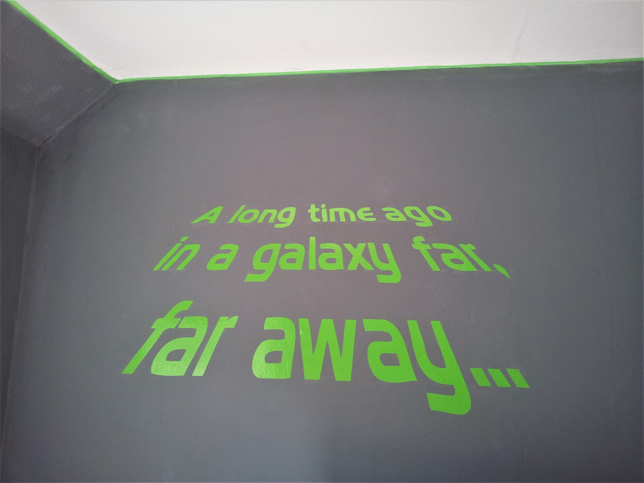 Star Wars Bedroom Makeover - lime green wall sticker on a grey wall that says "A long time ago in a galaxy far, far away..."