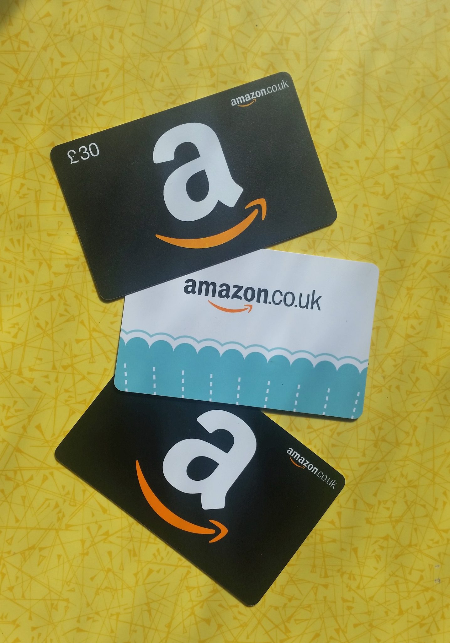 Amazon gift cards on yellow table
