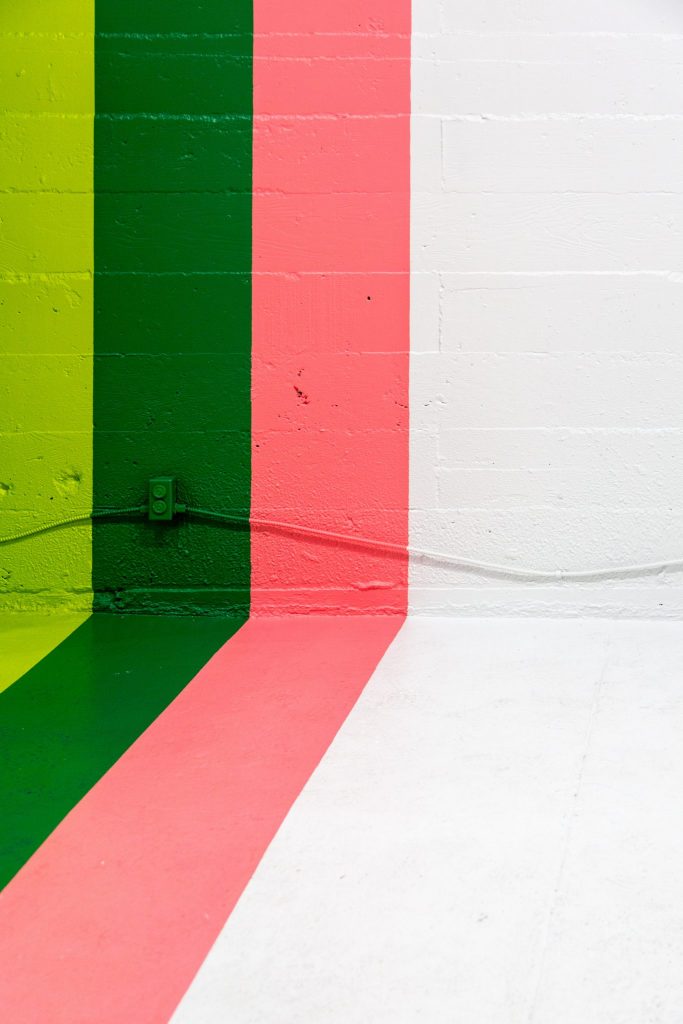 Lime, green and pink stripes on wall and floor.