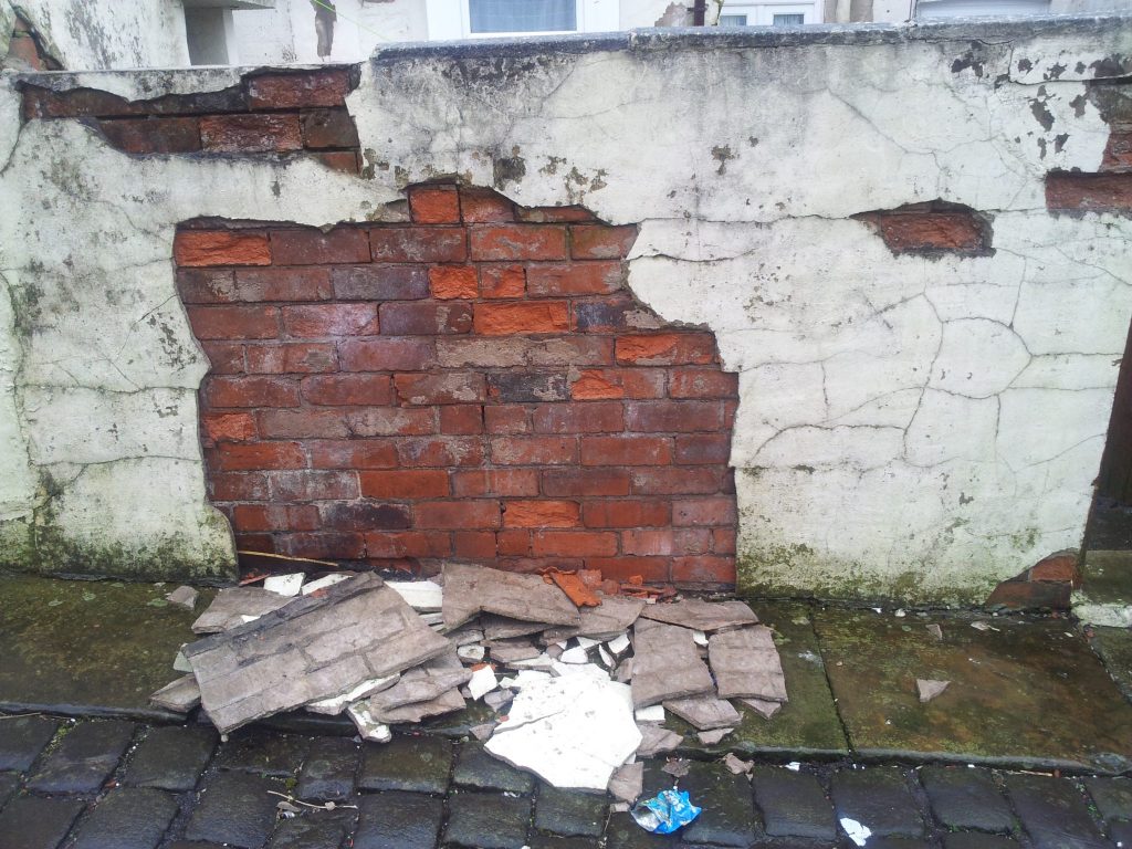 Poorly maintained wall with blown render.