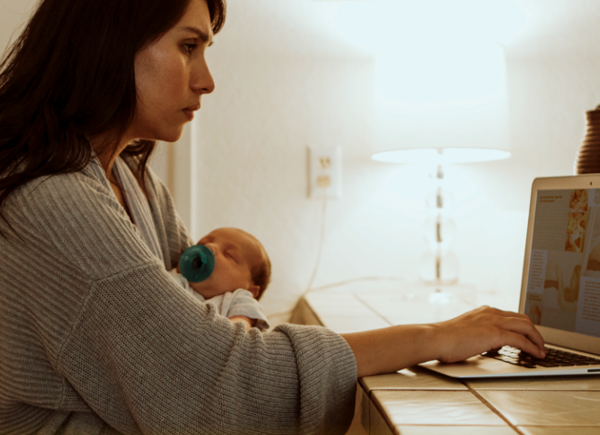 Mother holding baby while looking at laptop | 3 types of businesses you can start instead of joining an MLM