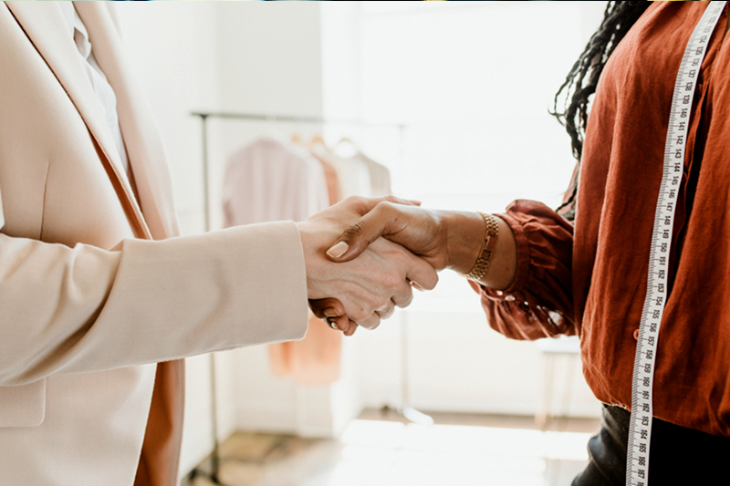 Fashion designer shaking hands with lender